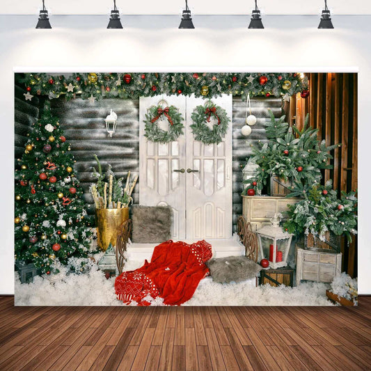 Festive Christmas backdrop featuring double doors with wreaths, a decorated Christmas tree, and snowy seasonal decorations like red blankets and lanterns.