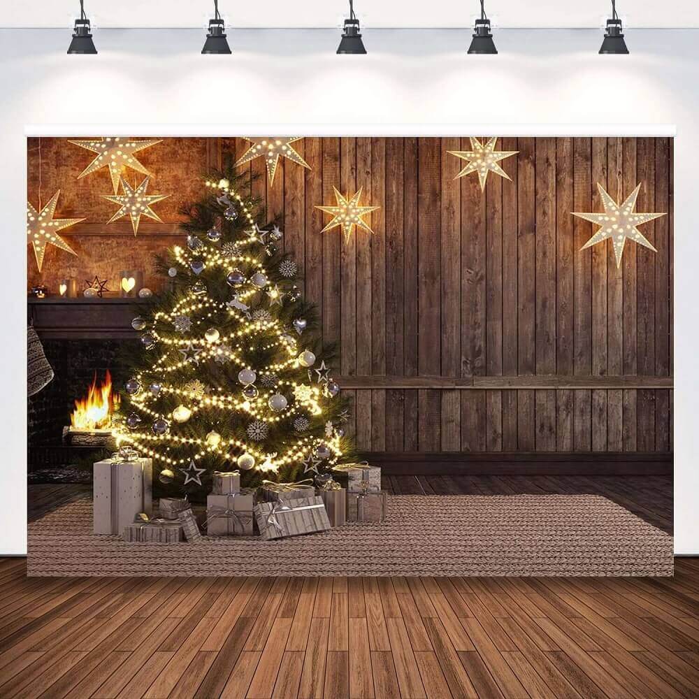 Rustic Christmas backdrop featuring a glowing tree with string lights and ornaments, a burning fireplace, and wooden wall decor with illuminated stars.