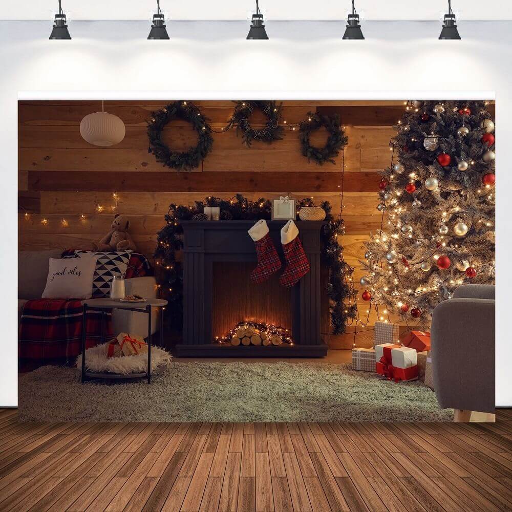 Cozy Christmas-themed backdrop featuring a glowing fireplace, decorated tree, rustic wooden wall with wreaths, and a soft rug with gifts and stockings.