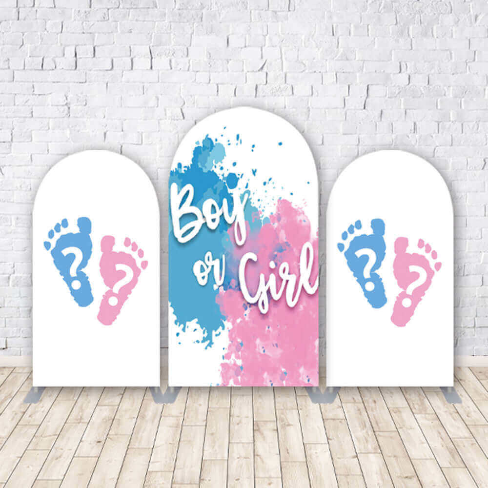 A gender reveal-themed arched backdrop set featuring a central arch with 'Boy or Girl' text in pink and blue paint splashes, flanked by two side arches with baby footprints and question marks in pink and blue.