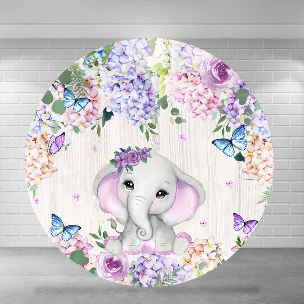 Round baby shower backdrop featuring a cute watercolor elephant with purple floral accents, surrounded by hydrangeas, roses, and butterflies against a wooden background.Round baby shower backdrop featuring a cute watercolor elephant with purple floral accents, surrounded by hydrangeas, roses, and butterflies against a wooden background.