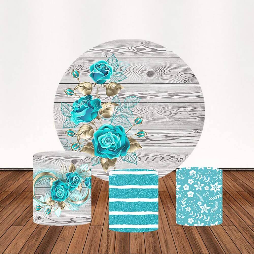 A rustic blue floral-themed decor set featuring a circular backdrop with vibrant blue roses, golden leaves, and a wooden texture, along with three decorative cylinder covers with floral and glitter patterns.