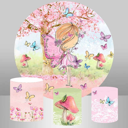 Whimsical fairy-themed birthday party backdrop featuring a pink-winged fairy, cherry blossoms, butterflies, mushrooms, and matching plinth covers in floral, butterfly, and mushroom designs.