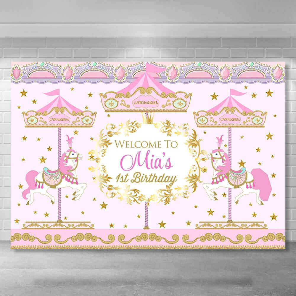 A pastel pink and gold carousel-themed birthday party backdrop with a whimsical design, featuring two carousel horses, ornate gold details, and the text "Welcome to Mia's 1st Birthday" in an elegant font.