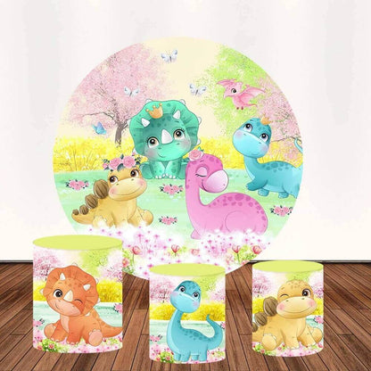 Dinosaur-themed party decor set featuring a round backdrop with cartoon dinosaurs in a pastel garden and three matching cylinder covers with individual dinosaur designs.