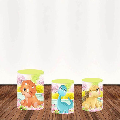 Three cylindrical covers featuring cartoon dinosaurs, including an orange Triceratops, a yellow Stegosaurus, and a blue Brontosaurus, set against a floral pastel background.