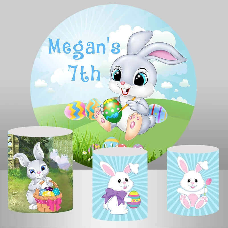 A set of Easter and 7th birthday photography props featuring a round backdrop with a bunny painting Easter eggs and the personalized message “Megan’s 7th,” along with three plinth covers decorated with playful bunny and Easter egg designs, perfect for kids’ parties and themed events.