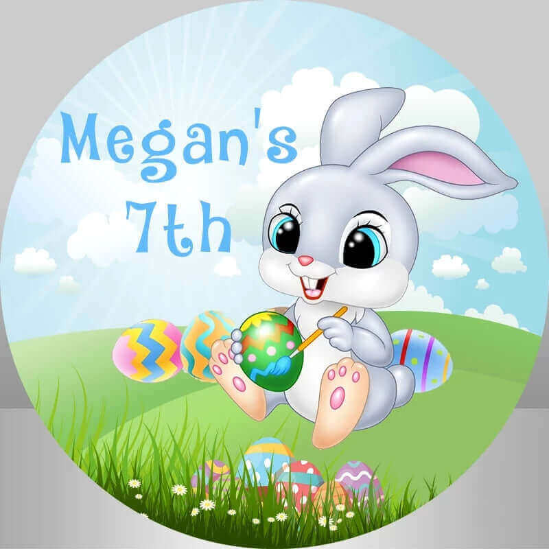 A personalized Easter-themed round backdrop with a cute bunny painting colorful Easter eggs, set against a grassy field and blue sky, ideal for a 7th birthday celebration or Easter party.