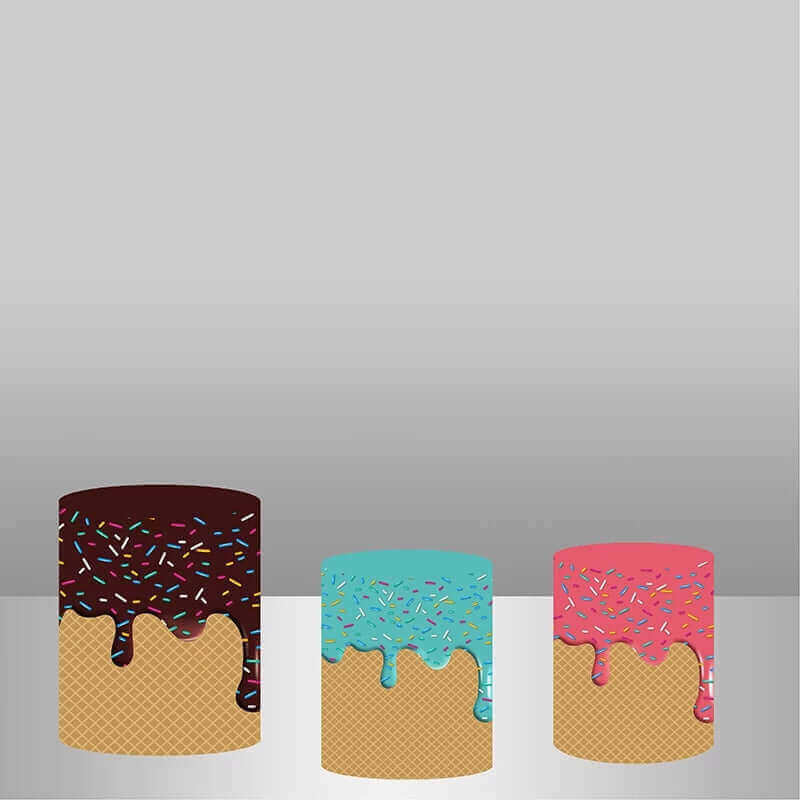 Set of three cylinder covers with waffle cone designs and colorful frosting drips in chocolate, blue, and pink, topped with sprinkles.