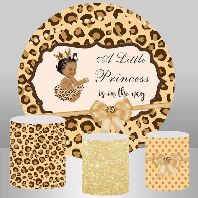 Leopard princess baby shower backdrop set featuring a round leopard print cover with "A Little Princess is on the way" text and three matching cylinder covers with leopard print, gold glitter, and polka dots, adorned with ribbon bows.