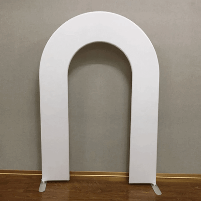 White open arch backdrop stand with a minimalist arched design, set against a neutral gray wall and wooden floor, ideal for weddings, birthdays, and modern event decor.