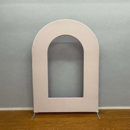 Neutral nude open arch backdrop stand with a minimalist design, set against a gray wall and wooden floor, ideal for modern weddings, birthdays, and event styling.