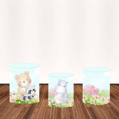 Three cylindrical covers featuring cartoon animals like a bear with a raccoon, a hippo with a baby, and floral patterns, designed to complement the jungle-themed backdrop.