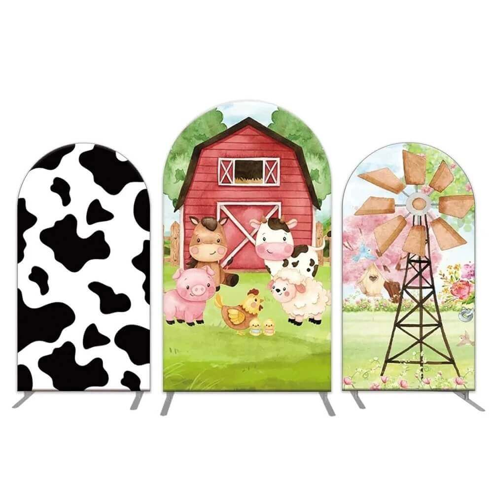 Set of three farm-themed arched backdrop covers featuring a cow print design, a red barn with cartoon farm animals, and a windmill in a countryside setting for farm-themed parties.