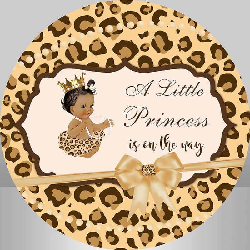 Round leopard print baby shower backdrop with "A Little Princess is on the way" text, gold ribbon bow, and a baby girl illustration wearing a leopard outfit and crown.