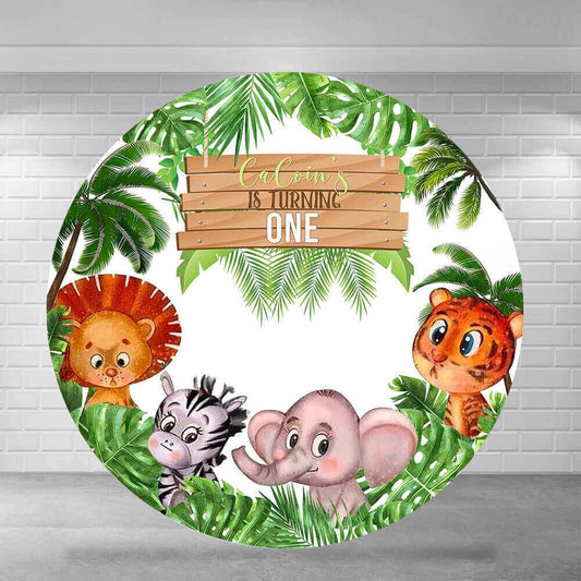 Round safari jungle-themed backdrop featuring a wooden sign reading "CaCoin's is Turning One," with a lion, zebra, elephant, and tiger surrounded by green tropical leaves and palm trees.