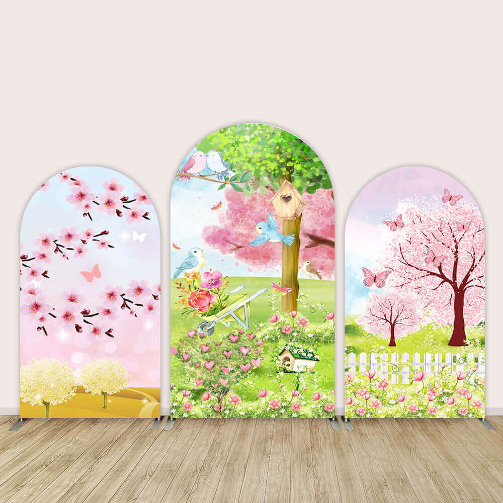 Spring-themed arch backdrop set with cherry blossoms, a birdhouse garden, and a floral landscape, perfect for weddings and spring celebrations.