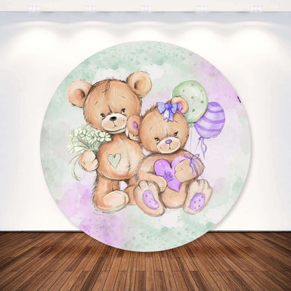 Round party backdrop featuring two teddy bears, one holding a bouquet and the other holding a heart, surrounded by green and purple balloons in a pastel design.