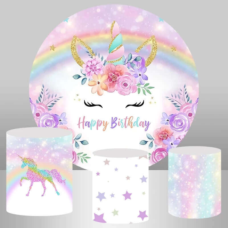 Unicorn-themed birthday party backdrop featuring a golden glitter unicorn horn, pastel rainbow, florals, and "Happy Birthday" text, paired with plinth covers showing a glitter unicorn, star pattern, and pastel glitter design.