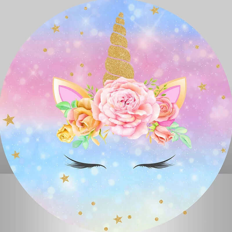 Round unicorn-themed backdrop with a golden glitter unicorn horn, pastel rainbow background, pink and yellow floral arrangement, and star details.