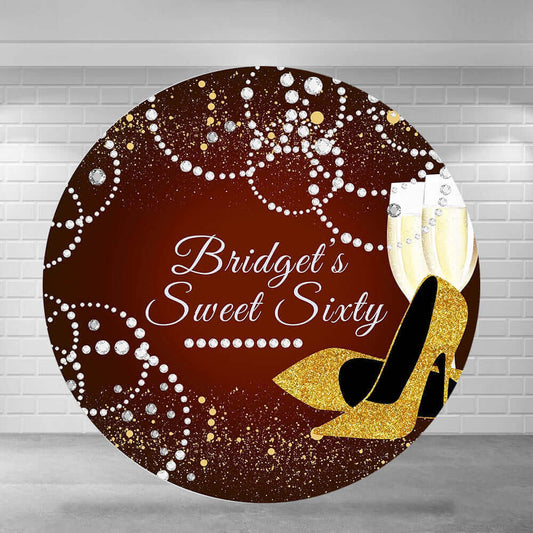 Elegant Sweet Sixty round backdrop featuring a burgundy wine background with gold glitter details, diamond-like patterns, a pair of golden high heels, and champagne glasses, perfect for a 60th birthday celebration.